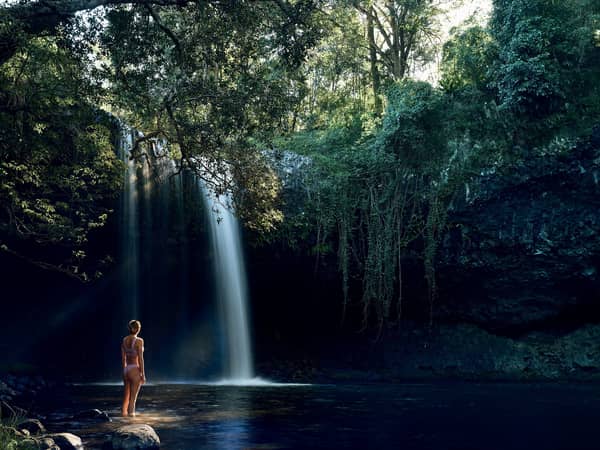 A swimmer below a rainforest waterfall near Newrybar, in the Byron hinterland