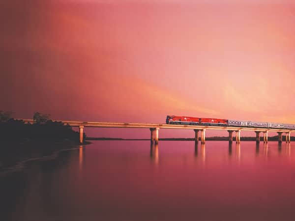 The Ghan crossing the Elizabeth River bridge near Darwin under a pink sky