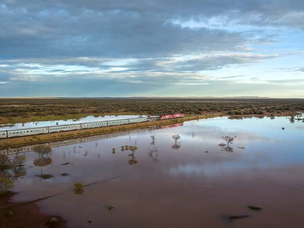 The Ghan reflected in floodwater at the edge of the outback