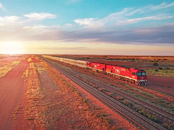 The Ghan crossing red outback plains at dusk