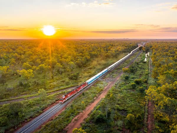 Aerial view of the Ghan heading through Top End woodland at sunset